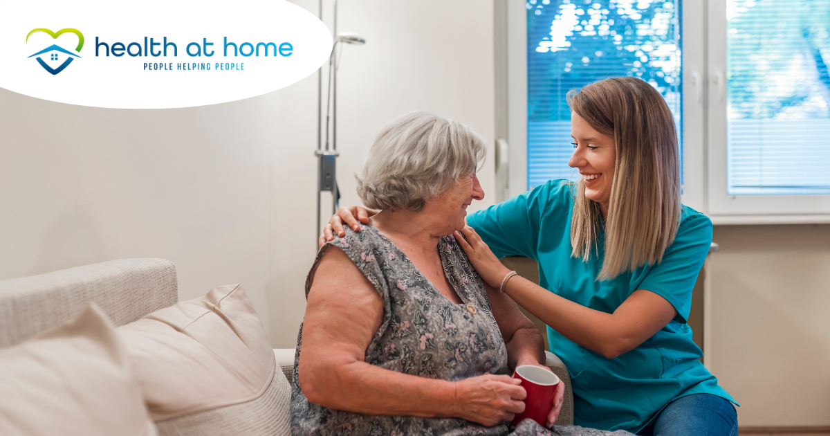 A home care provider compassionately tends to a senior client in their home.