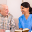 A professional caregiver enjoys her flexible career as she cares for and reads to an older client.